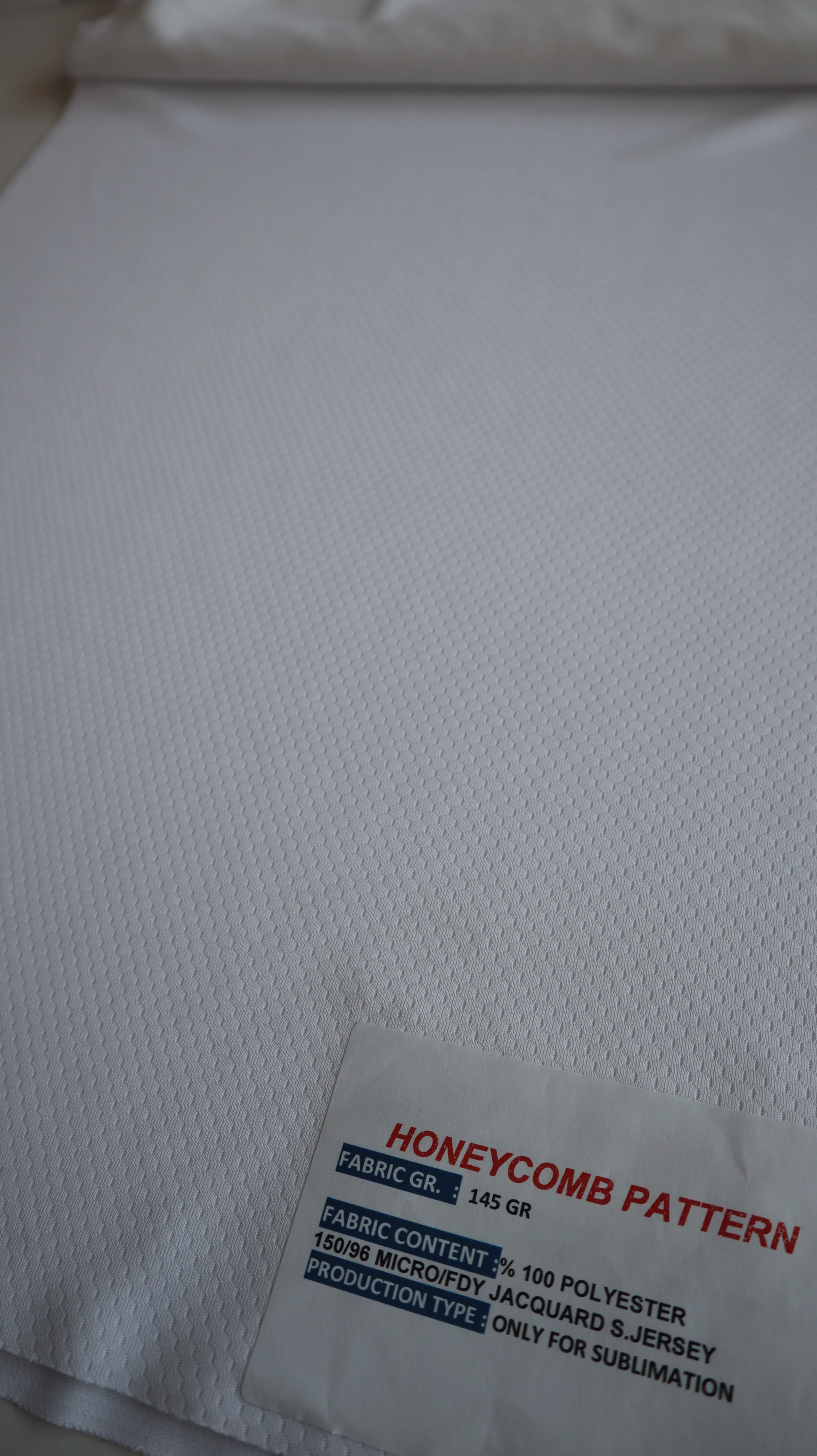 Performance sportswear fabric construction close-up showing knit surface and stretch